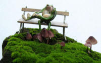 bronze frogs on park bench